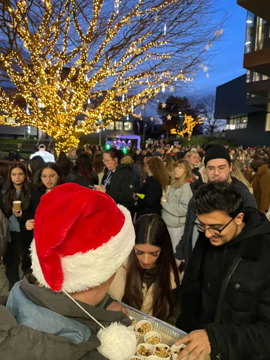 A person in a santa hat giving out free food