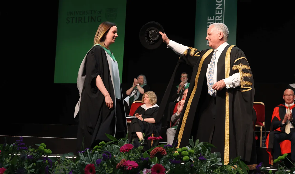 student on stage at graduation