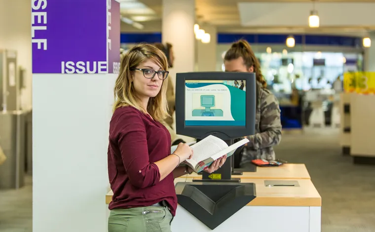 student in library self service computer