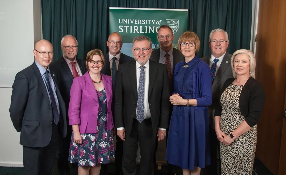 six men and three women stand assembled 