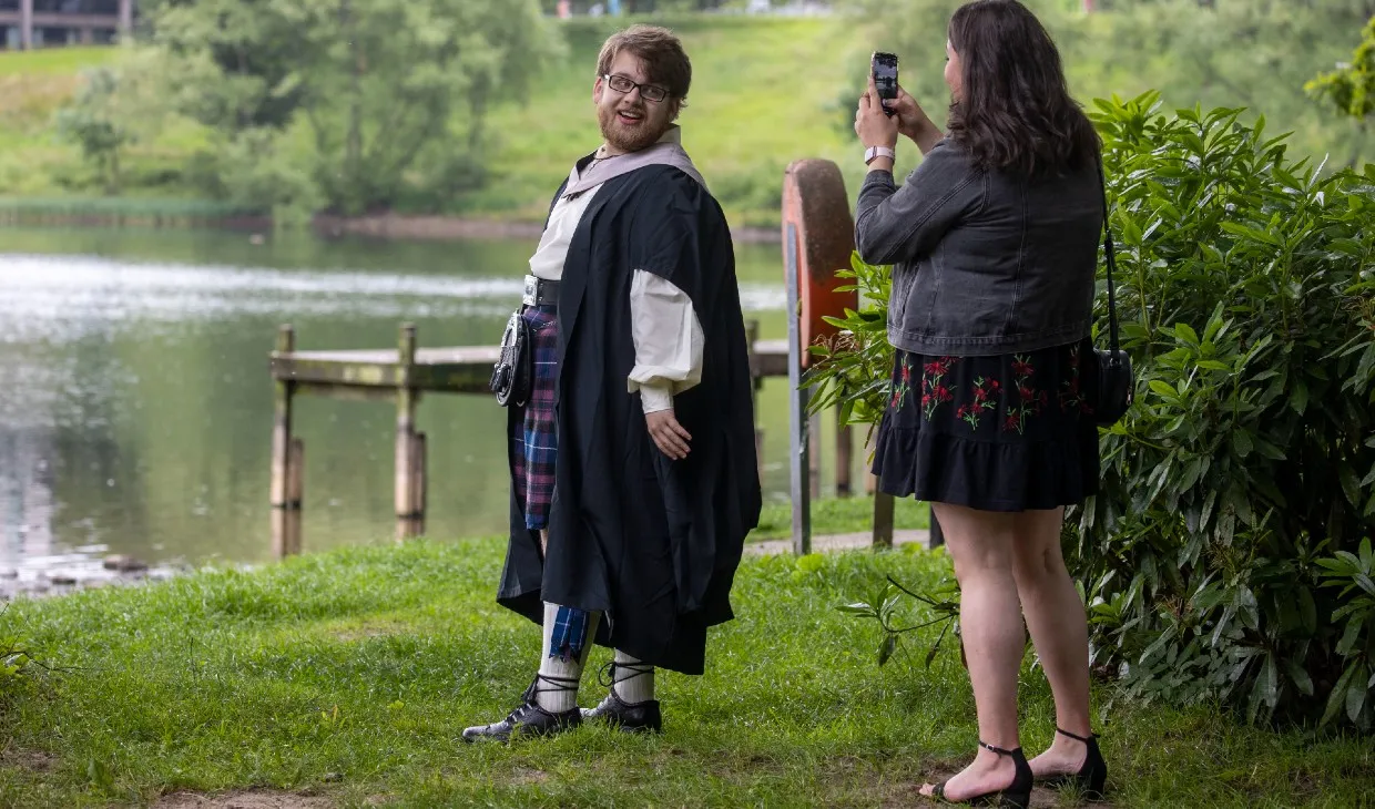 Graduate poses for picture at the gown