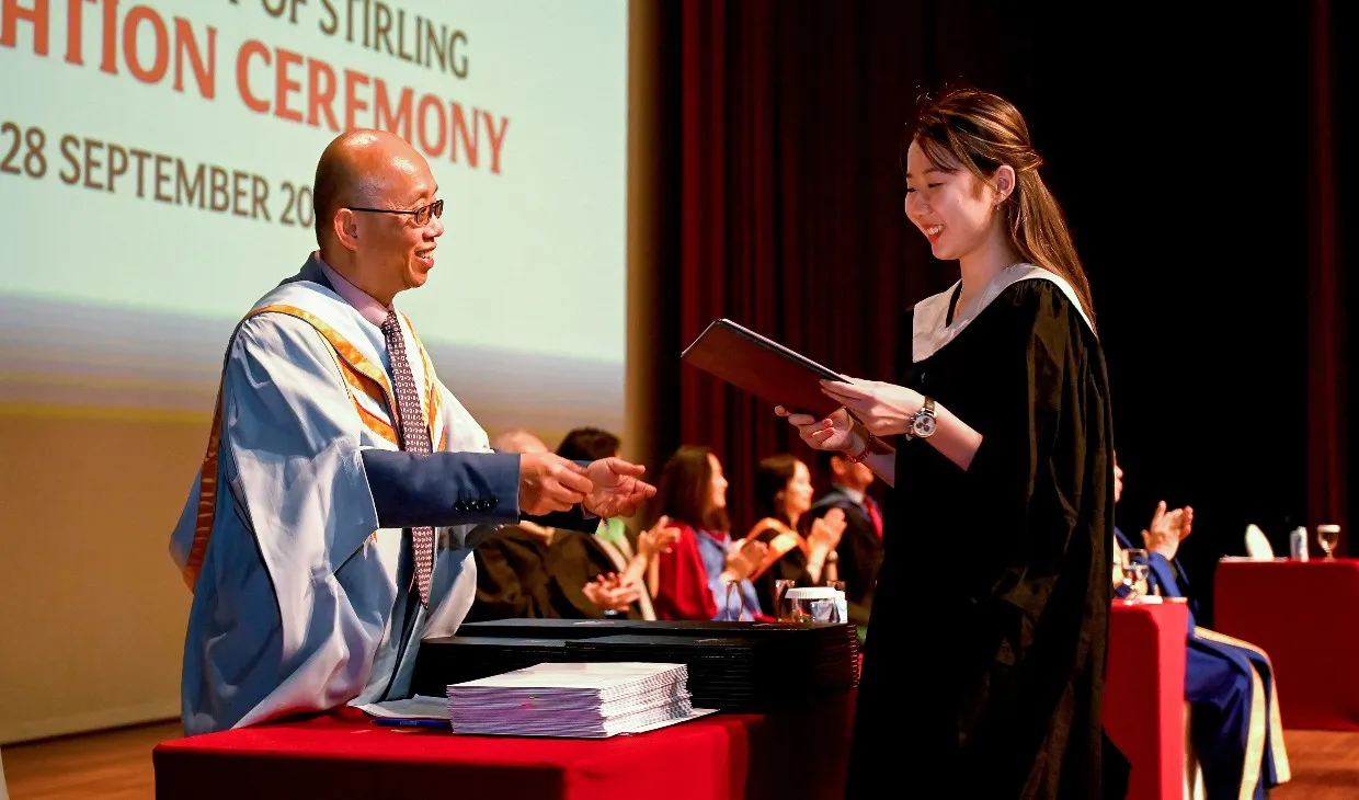 A Singapore graduate receiving their degree during the ceremony