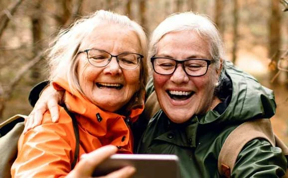 Two women smiling and looking at a phone
