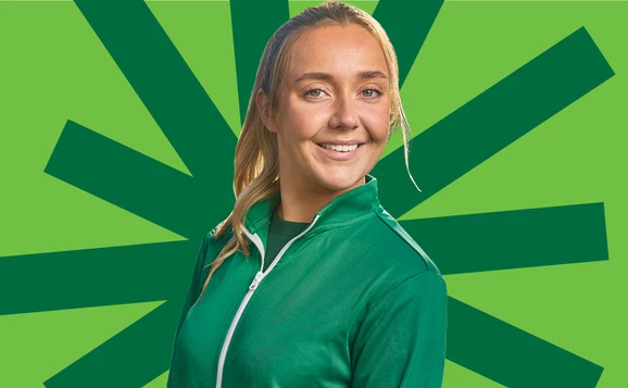 Student in green top against green background.