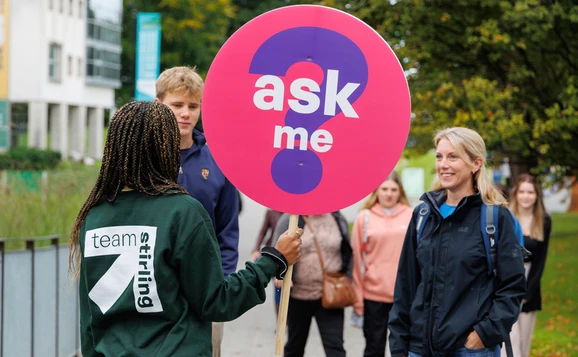 Student ambassador holding a sign saying ask me