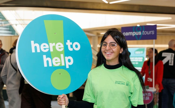 Student ambassador with a here to help sign