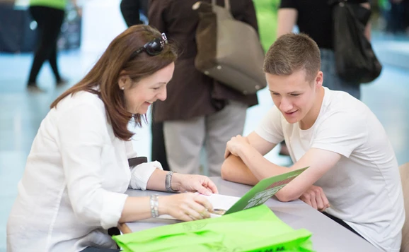Two people sat at a table looking at a prospectus