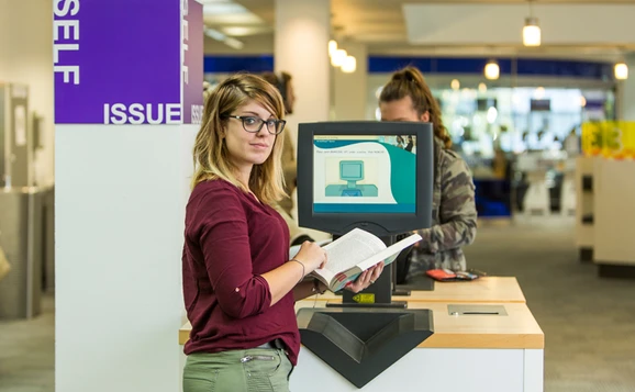 student in library self service computer