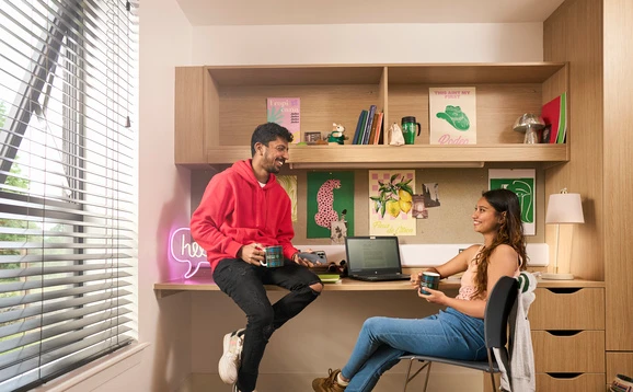 Two students chatting in a room in student accommodation