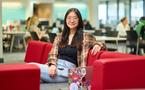 Student sitting on a sofa in the library