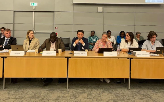 Panel of speakers behind a desk