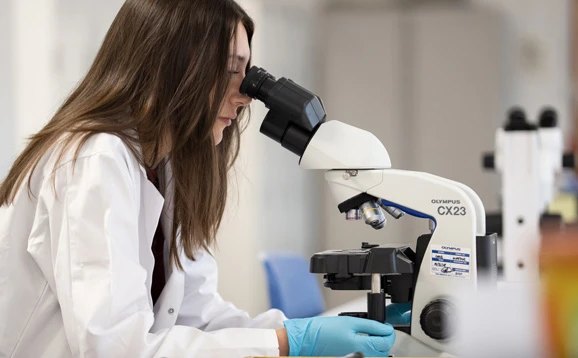 scientist looking through a microscope