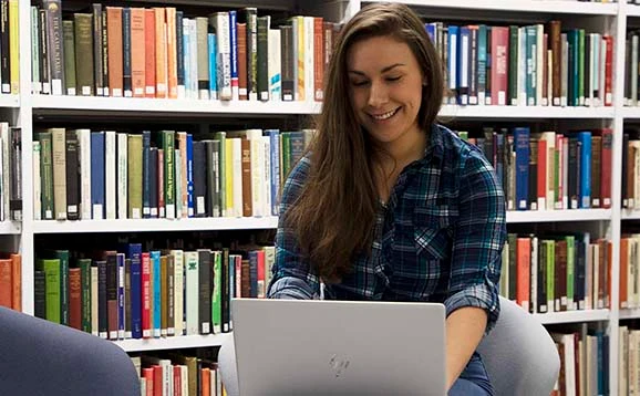 Student using a laptop in the library