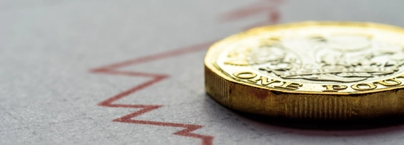 Pound coin lying on an economic graph.