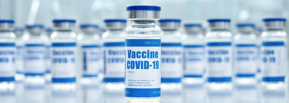 Vials of clear liquid marked with COVID-19 vaccine labels
