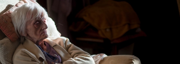 Elderly lady sitting in the dark