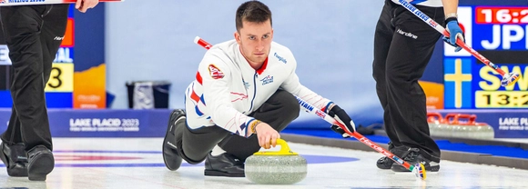 James Craik slides a stone down the sheet during the World University Games in Lake Placid.