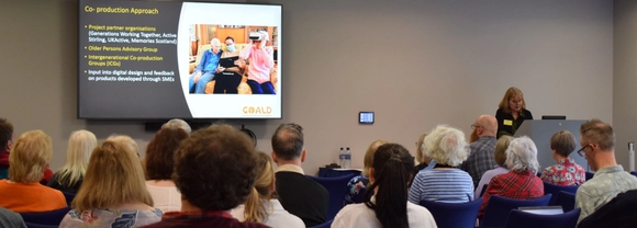 People seated in a conference room watching a presentation