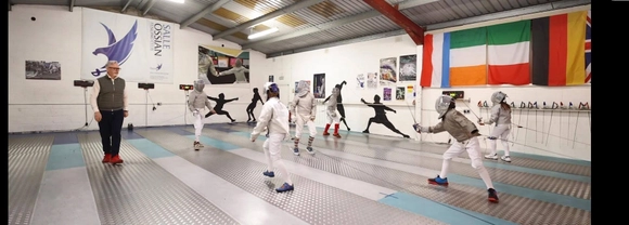 Philip Carson coaches fencing students at his fencing club