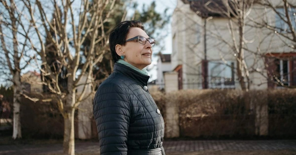 older woman in front of houses