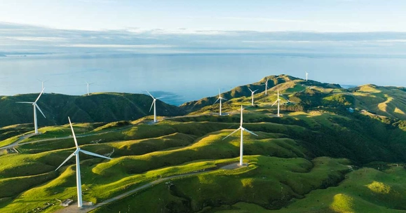 A windfarm on hills overlooking the sea
