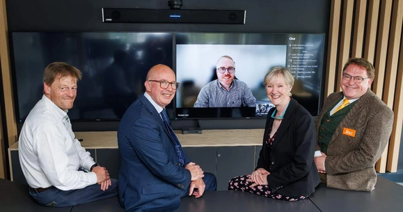 men and a woman sitting on table in front of screen