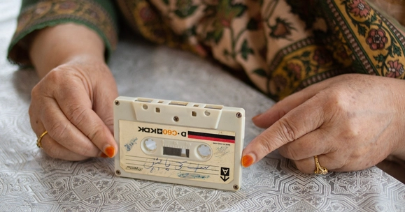 woman's hands holding cassette tape