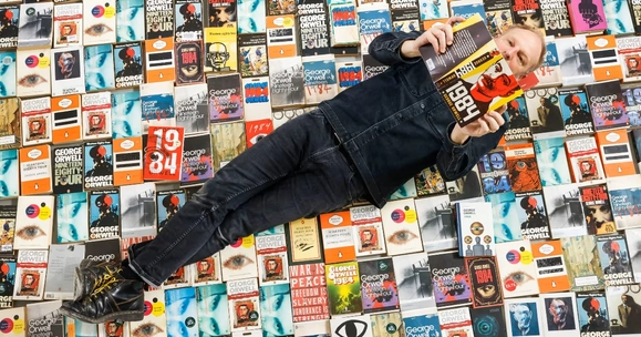 man lying on books reading