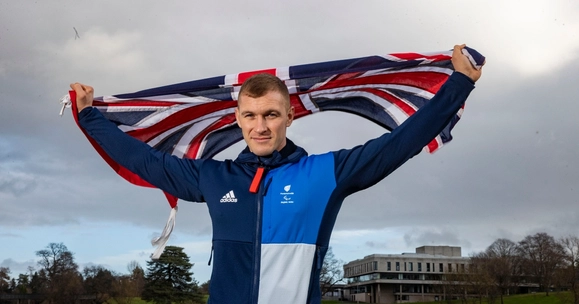 Scott Meenagh holding a Union Flag above his head.