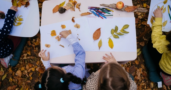 children at table with autumn leave outside