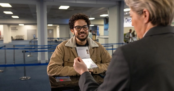 A man has his passport checked at an airport's border control
