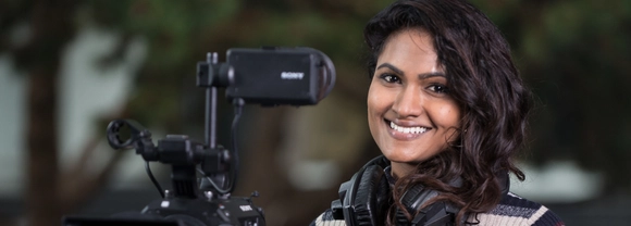 Postgraduate student with filming camera and headphones