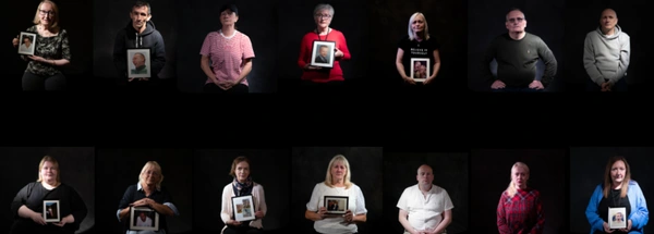 People sitting holding photographs