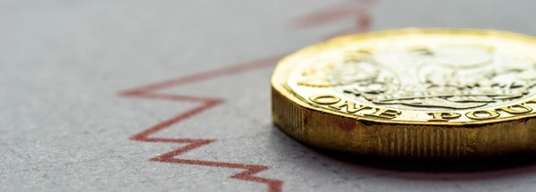 Pound coin lying on an economic graph.