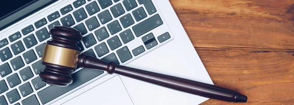 Judge gavel lying on laptop keyboard
