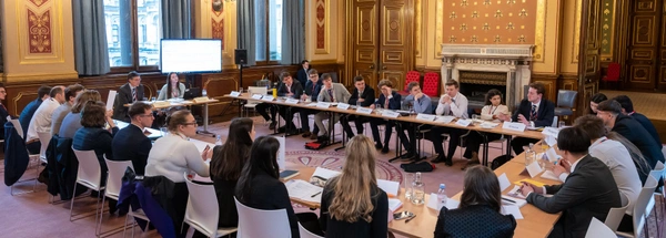 Student delegates sitting round the table at the Model NATO event at the Foreign Office