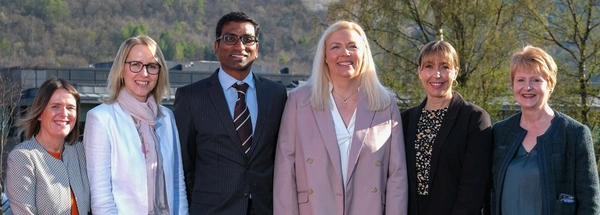 Six healthcare experts and academics stood next to each other outside