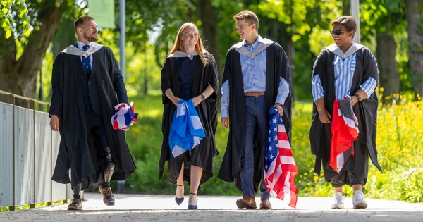 Graduating athletes Scott Meenagh, Louise Duncan, Tristen Bell and Gabriella Wood walk towards camera.