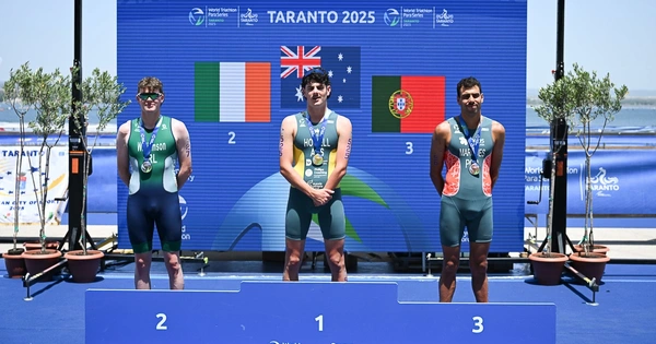 Tom Williamson stands on the podium after winning silver.