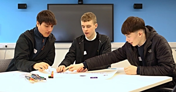 three male school pupils at a desk