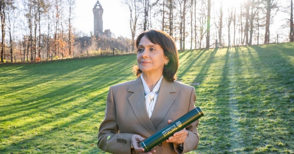 woman holding graduation scroll outside