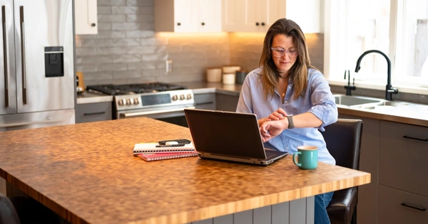 woman working from home looking at watch