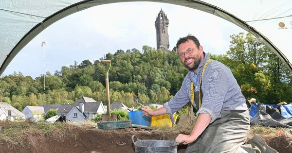 man with trowel outside digging