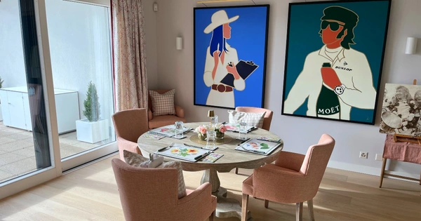 Dining room table and chairs with bold prints on wall