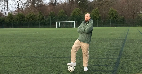 Man with foot on football standing on pitch