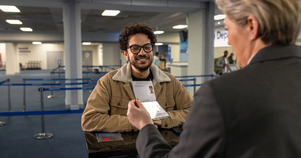 A man has his passport checked at an airport's border control