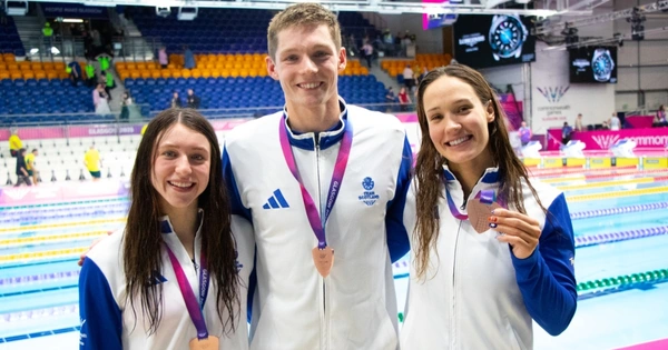 Keanna MacInnes, Duncan Scott and Angharad Evans celebrate after winning bronze.