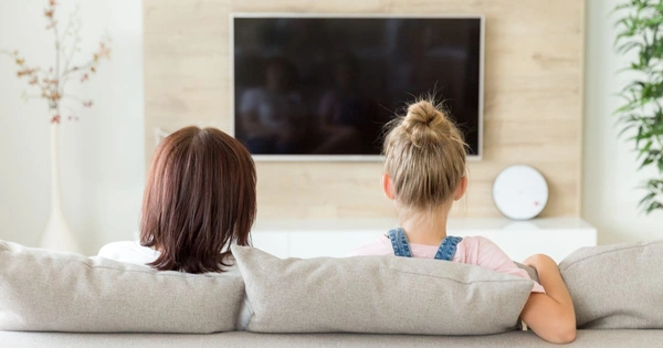 Two females watching a large flat screen TV