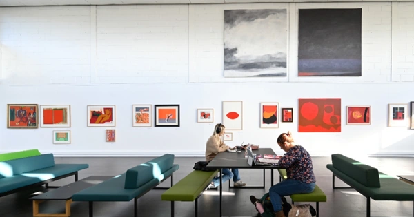 People sitting at tables with art on wall in background