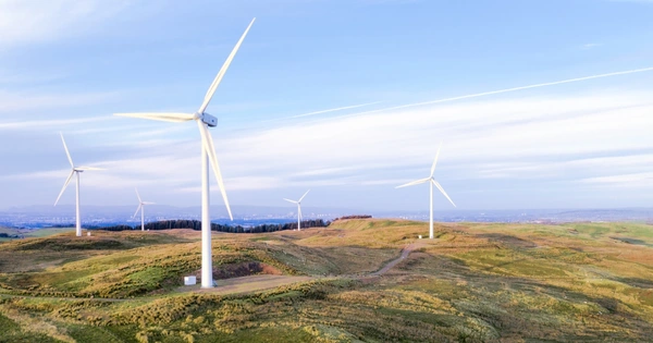 Wind turbines on a hill with blue sky